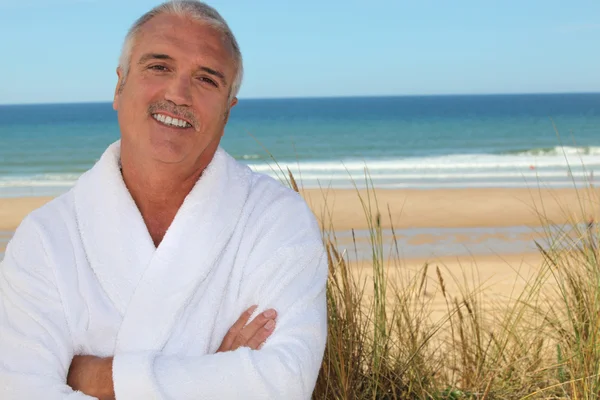 Man in badjas op het strand — Stockfoto