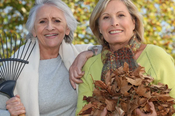 Zwei Frauen harken Blätter — Stockfoto