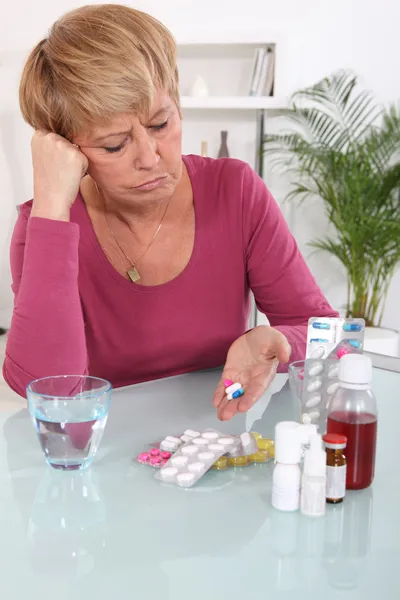 Middle-aged woman taking her medication — Stock Photo, Image