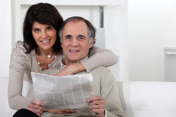 Couple d'âge mûr regardant un journal — Photo