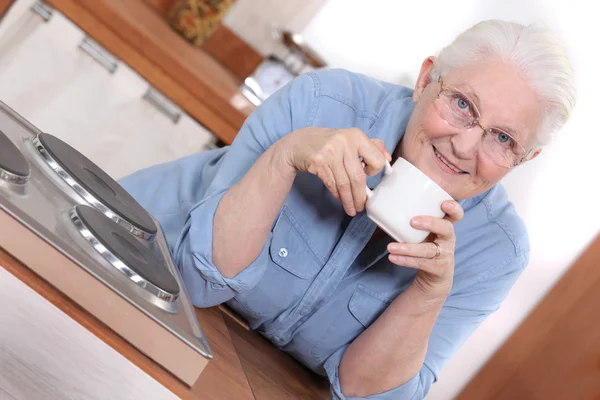 Mujer mayor disfrutando de una taza de té — Stockfoto