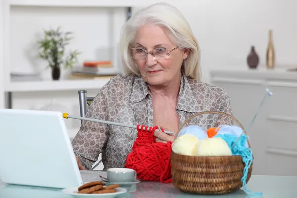 ラップトップで編み物年上の女性 — ストック写真