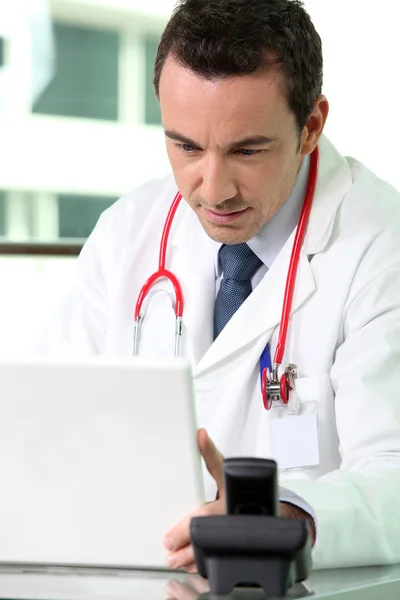 En läkare titta på sin laptop — Stockfoto