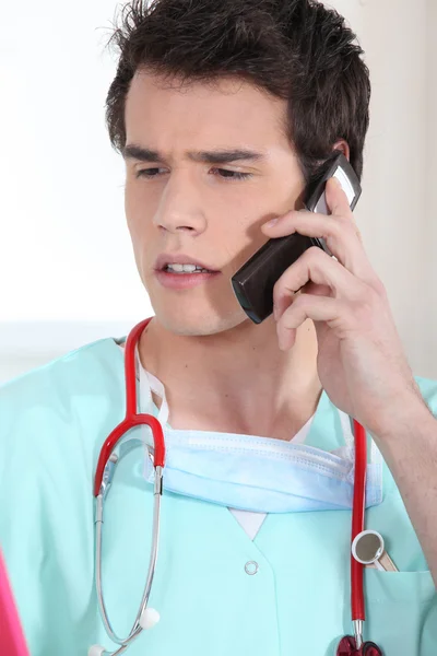 Médico estressado falando em seu telefone celular — Fotografia de Stock