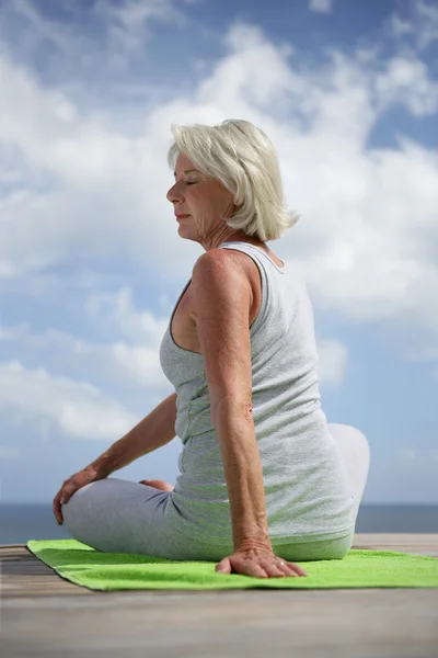 Middle-aged woman doing yoga outdoors — Stock Photo, Image