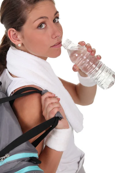 Женщина пьет воду после занятий спортом — стоковое фото