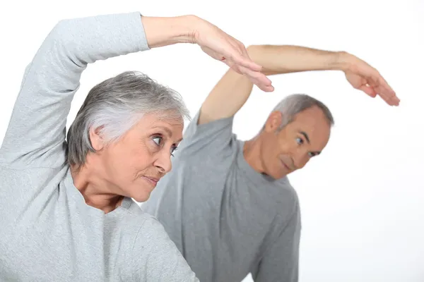 Äldre par stretching i gymmet — Stockfoto