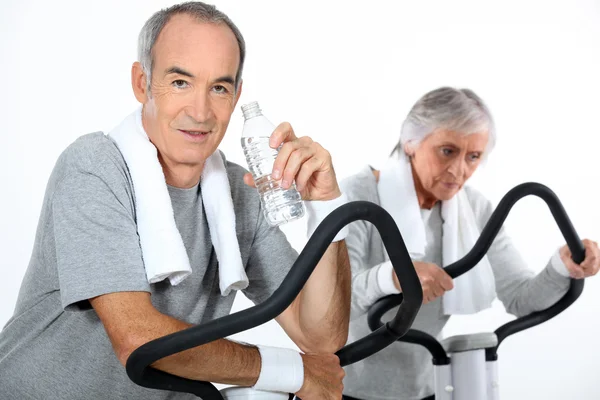65 años de edad, mujer y hombre haciendo entrenamiento cardiovascular —  Fotos de Stock