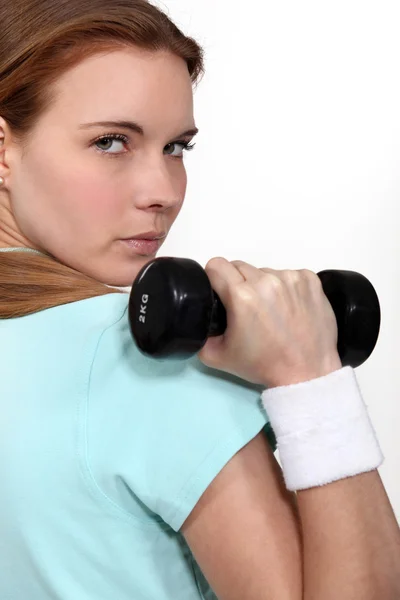 Een vastberaden vrouw opheffing van een halter — Stockfoto