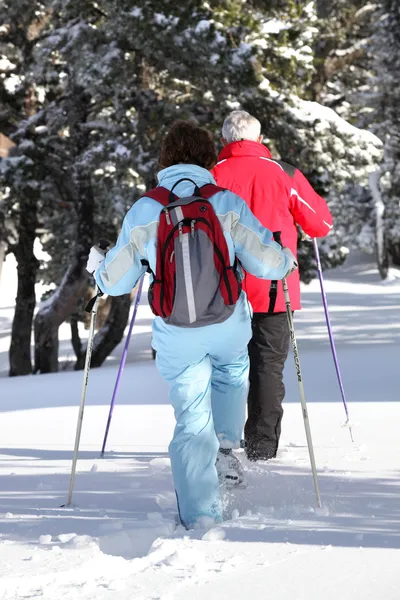 Middle-aged couple cross-country skiing — Stock Photo, Image
