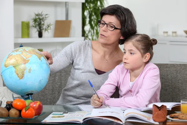 Mother and young daughter doing her homework Stock Photo