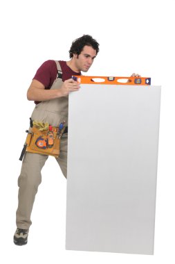 Carpenter with a spirit level and blank board clipart