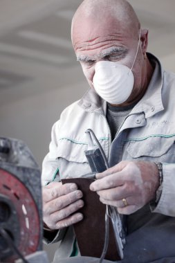 Man wearing mask whilst sanding clipart