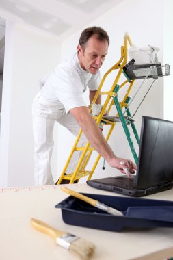 A painter typing on his laptop clipart