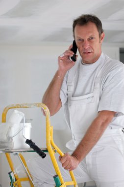 Painter answering phone whilst working clipart