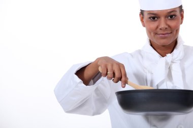 Female cook with a high-sided frying pan and a wooden spoon clipart