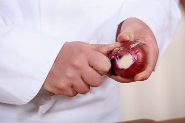 Male hands peeling onions clipart