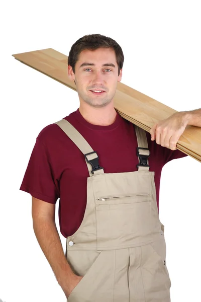 Carpenter carrying plywood — Stock Photo, Image