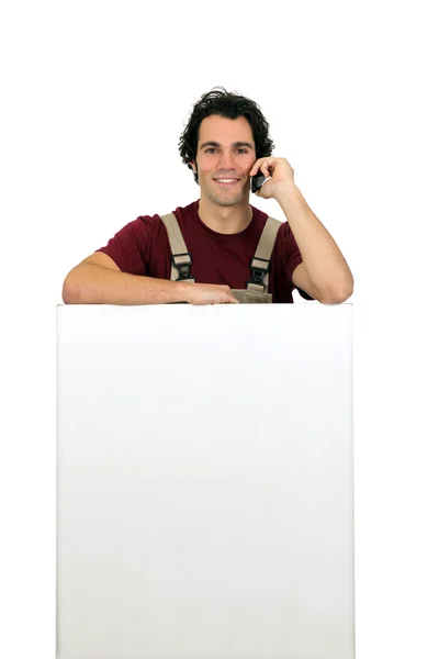 Carpinteiro no telefone por placa de conta em branco — Fotografia de Stock