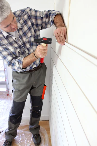 Carpenter nailing panels to house — Stock Photo, Image
