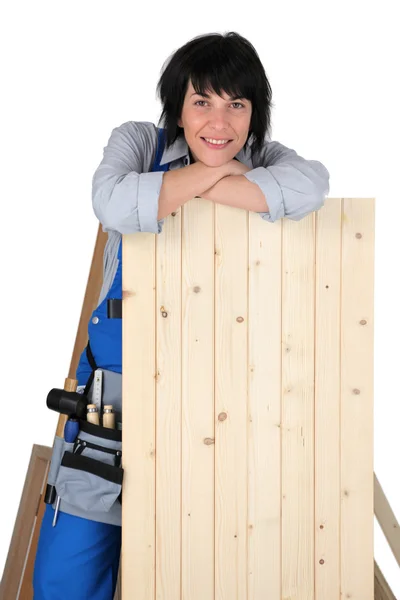 Mulher carpinteiro inclinado em uma prancha — Fotografia de Stock