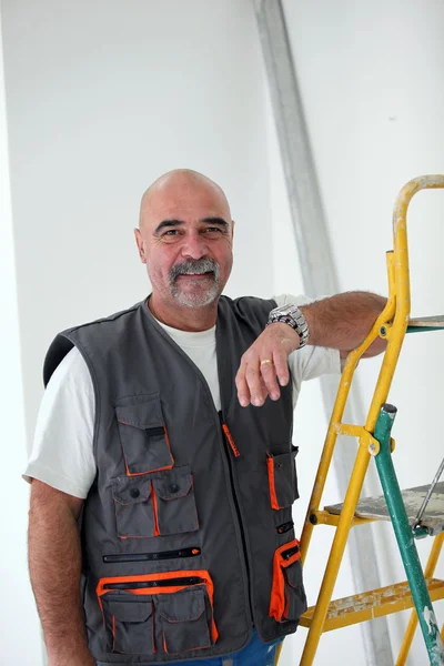 Plešatý údržbář pózuje žebřík — Stock fotografie