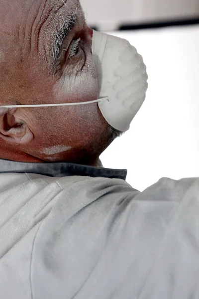 Man gezichtsmasker te dragen terwijl schuren muur — Stockfoto