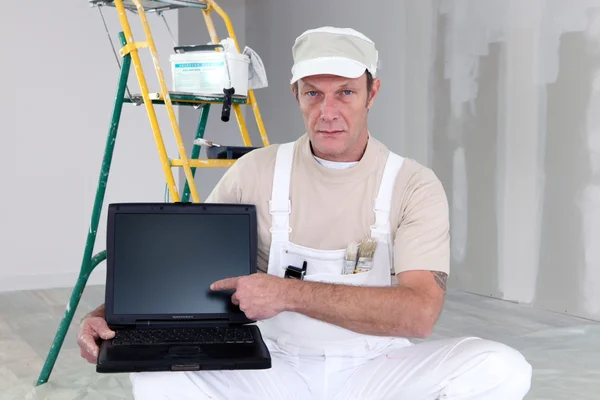 Painter pointing to his laptop — Stock Photo, Image
