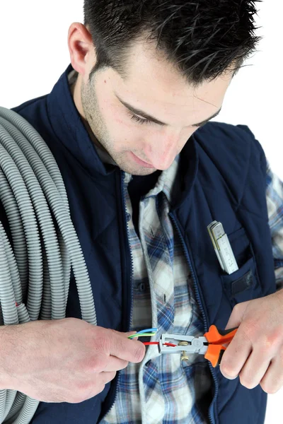 Eletricista cortando cabo elétrico — Fotografia de Stock