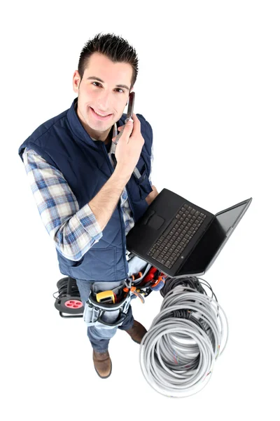 Electrician with laptop making a call — Stock Photo, Image