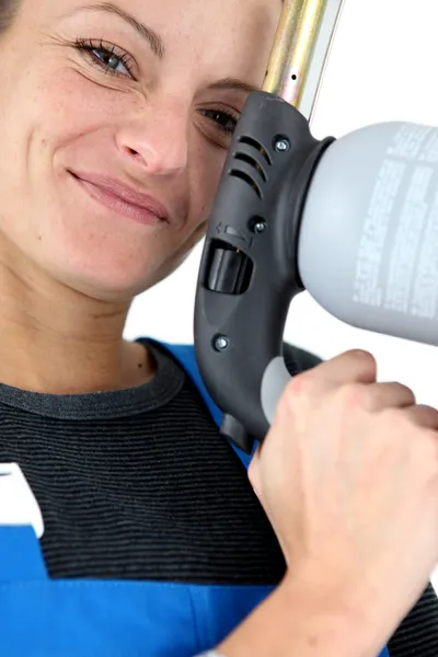 Closeup portrait of young blonde female apprentice holding spot welder — Stock Photo, Image