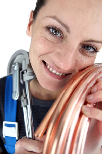 Mulher com tubo de cobre e ferramenta de dobra — Fotografia de Stock