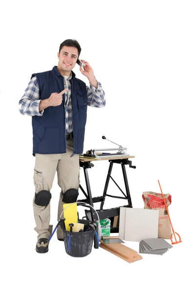 Tiler pointing to mobile whilst making a call — Stock Photo, Image