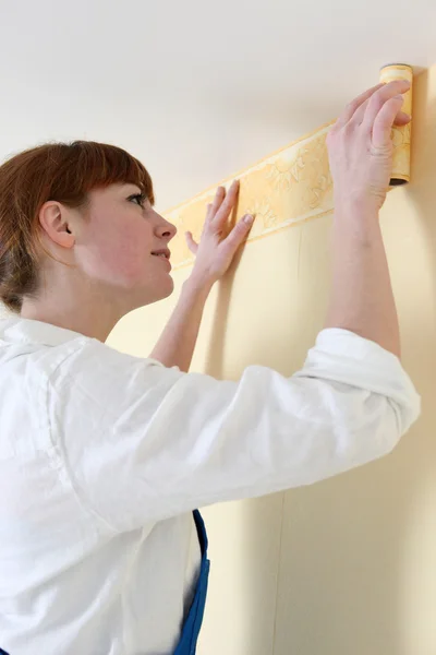 Mulher colocando uma fronteira papel de parede — Fotografia de Stock