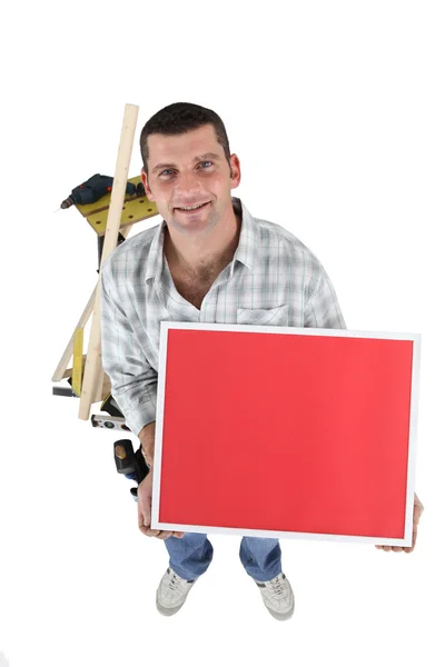 Handyman with a board left blank for your message — Stock Photo, Image