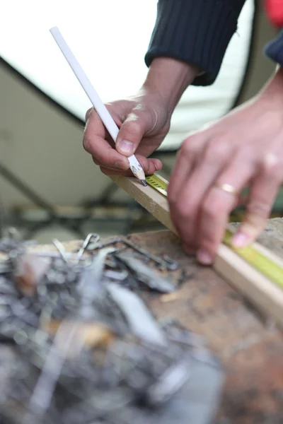 Constructor que marca la madera con un lápiz — Foto de Stock