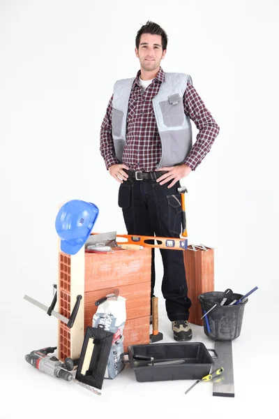 Brick layer proudly standing by his equipment — Stock Photo, Image