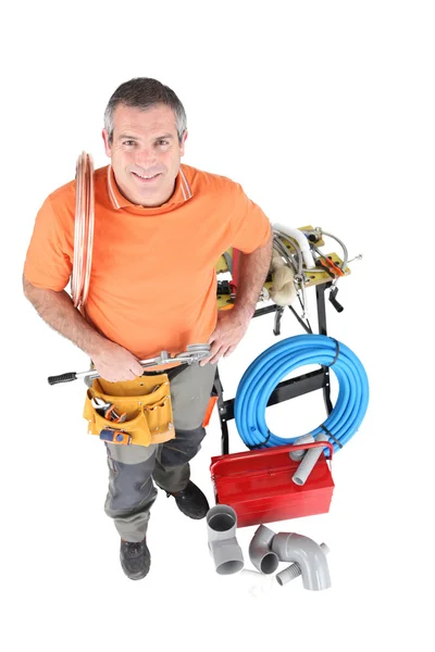 stock image Plumber with copper pipes holding tool