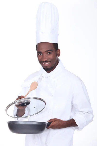 Черный шеф-повар держит сковороду — стоковое фото