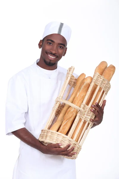 Пекарь с корзиной багетов — стоковое фото