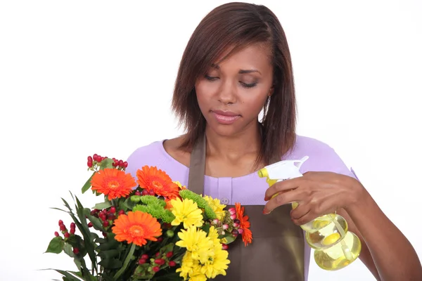 Fiorista spruzzare un mazzo di fiori con acqua — Foto Stock