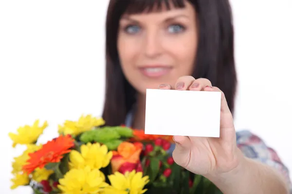 Флорист с букетиком цветов и визиткой, оставленной пустым для вашего сообщения — стоковое фото
