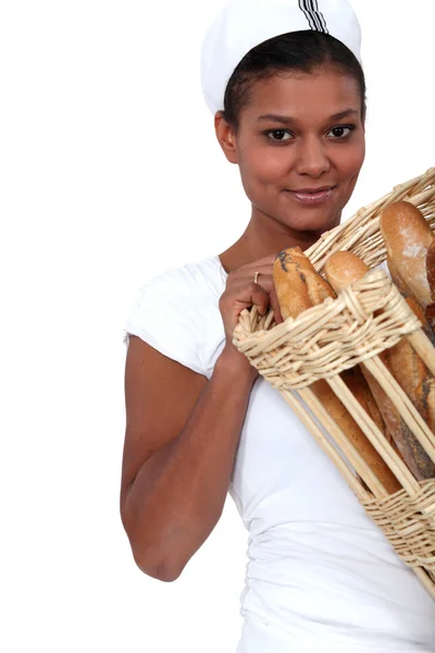 Vrouw bakker met een mandje van brood — Stockfoto