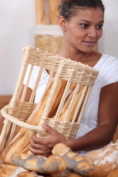 Vrouw met stokbrood in een bakkers — Stockfoto