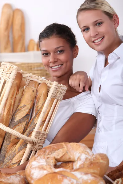 Две молодые женщины, работающие в пекарне — стоковое фото