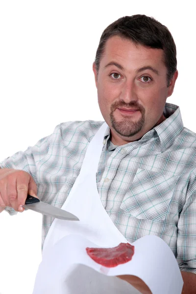 Мясник на белом фоне с мясом и ножом — стоковое фото