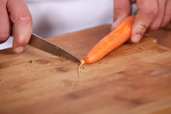 Chef tranchant une carotte — Photo