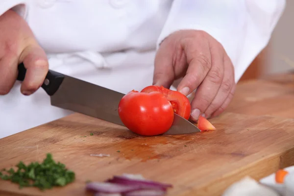Cuire en coupant une tomate — Photo