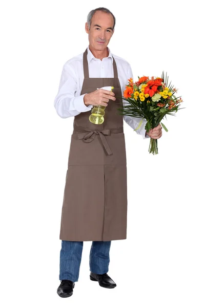 Florist spraying a bouquet of flowers — Stock Photo, Image