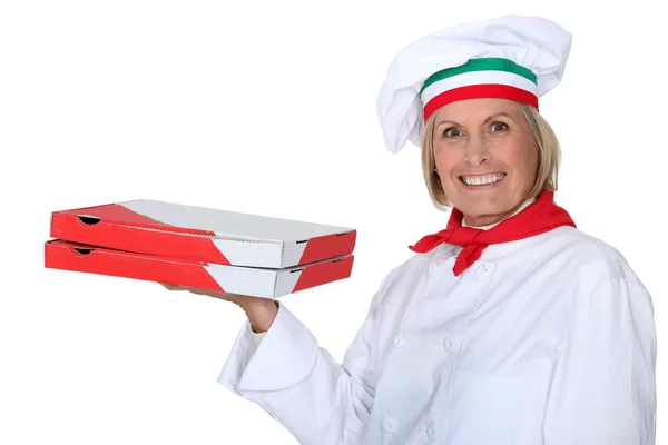 Maturo femmina pizza cuoco holding pizza packets — Foto Stock